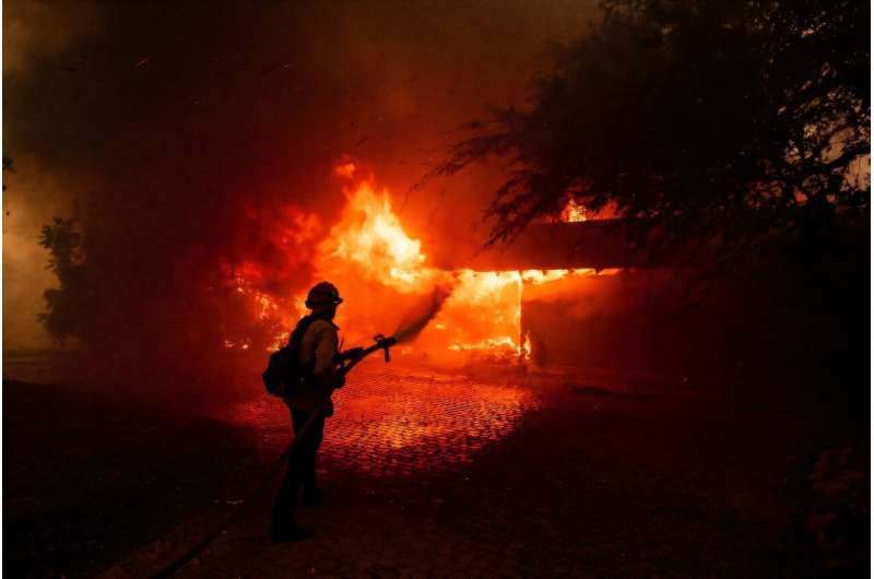 A fast-moving fire near Los Angeles has forced thousands from their homes and destroyed dozens of properties